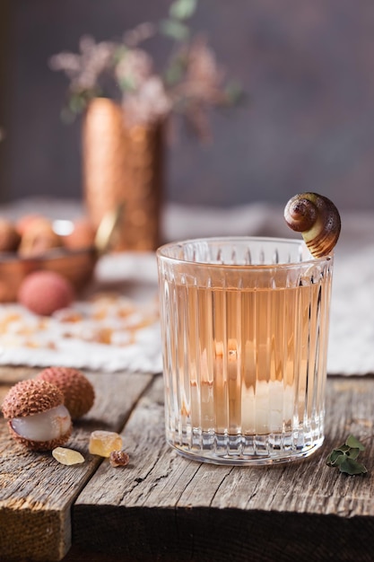 Copo de suco de lichia gelado na velha mesa de madeira, estilo rústico