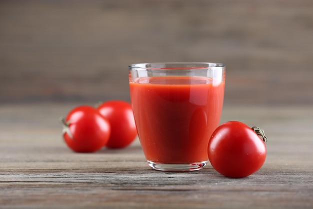 Copo de suco de tomate com legumes na mesa de madeira close-up