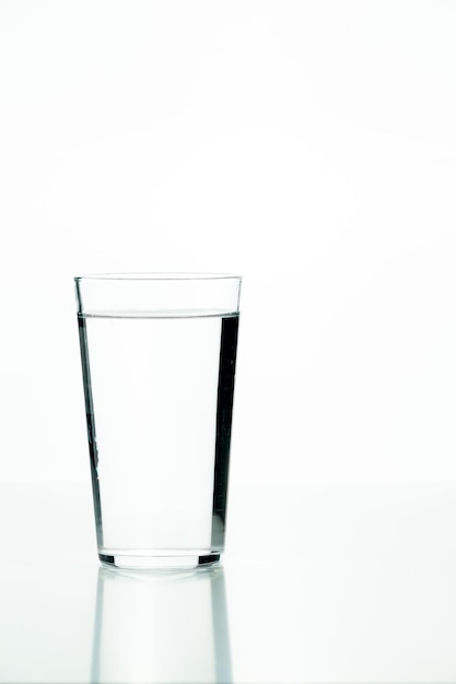 Copo de vidro cheio de água em um fundo branco