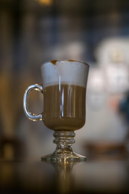 Foto copo de vidro com latte está na mesa na cafeteria copo com caramelo cappuccino na mesa