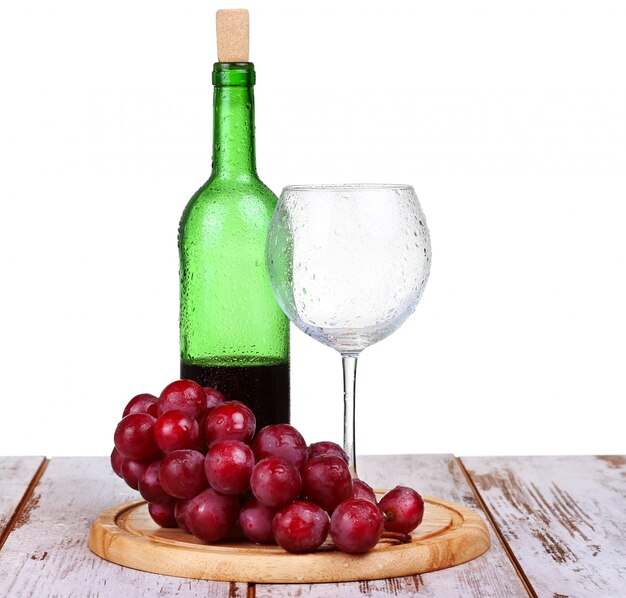 Copo de vinho com vinho tinto, garrafa de vinho e uvas isoladas sobre fundo branco