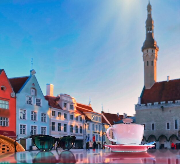 copo de vinho e xícara de café e vela na mesa de café de rua na cidade medieval de Tallinn cidade velha