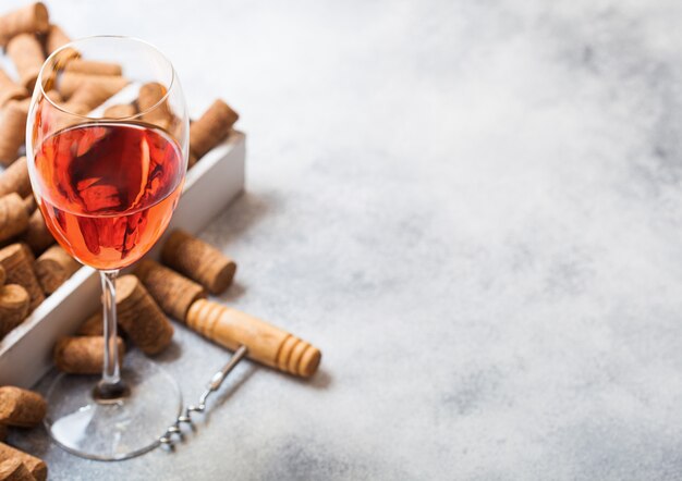 Copo de vinho rosé com muitas rolhas