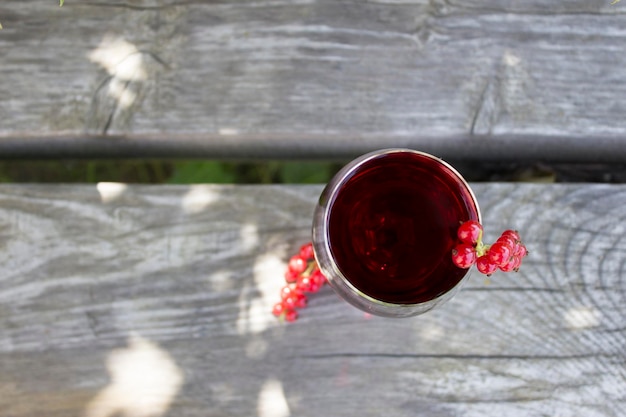 Copo de vinho tinto com groselhas no conceito de vinificação natural