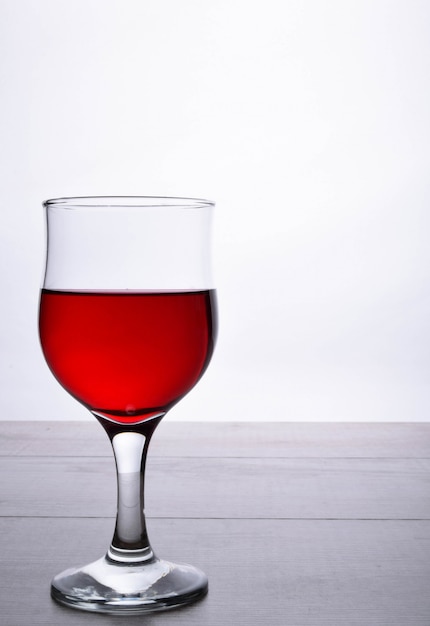 copo de vinho tinto. copo de vinho sobre um fundo claro de madeira