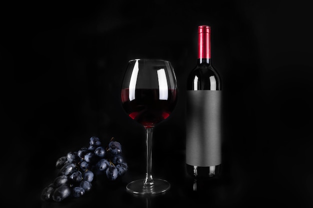 Copo de vinho tinto e garrafa e cacho de uva