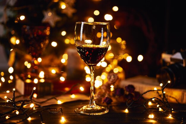 Copo de vinho tinto. fundo de bokeh. férias de natal, ano novo ou são valentim.