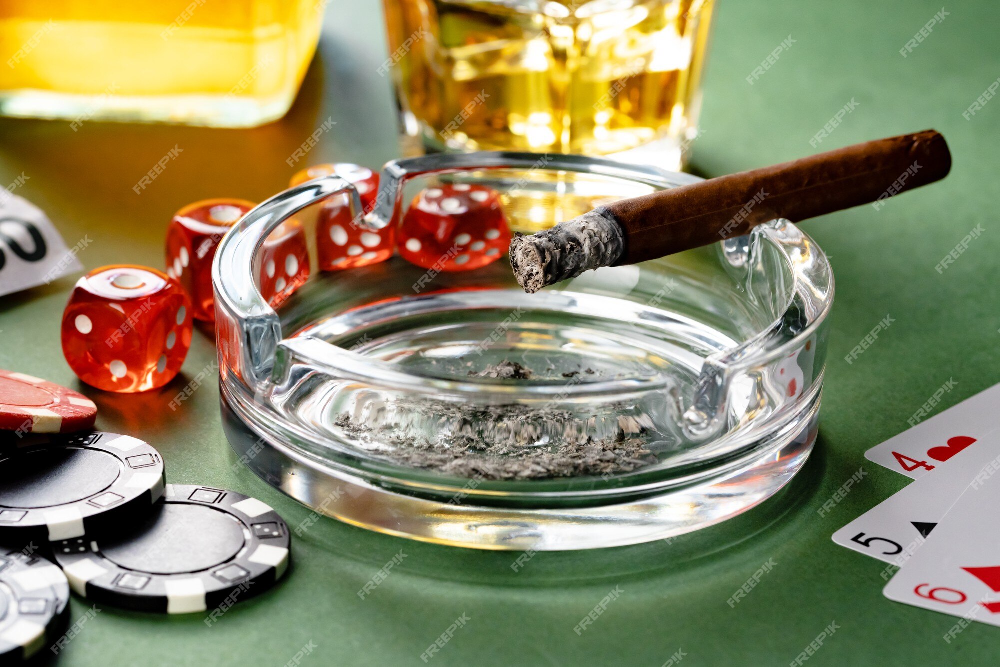 Copo de whisky charuto jogando cartas e fichas no verde