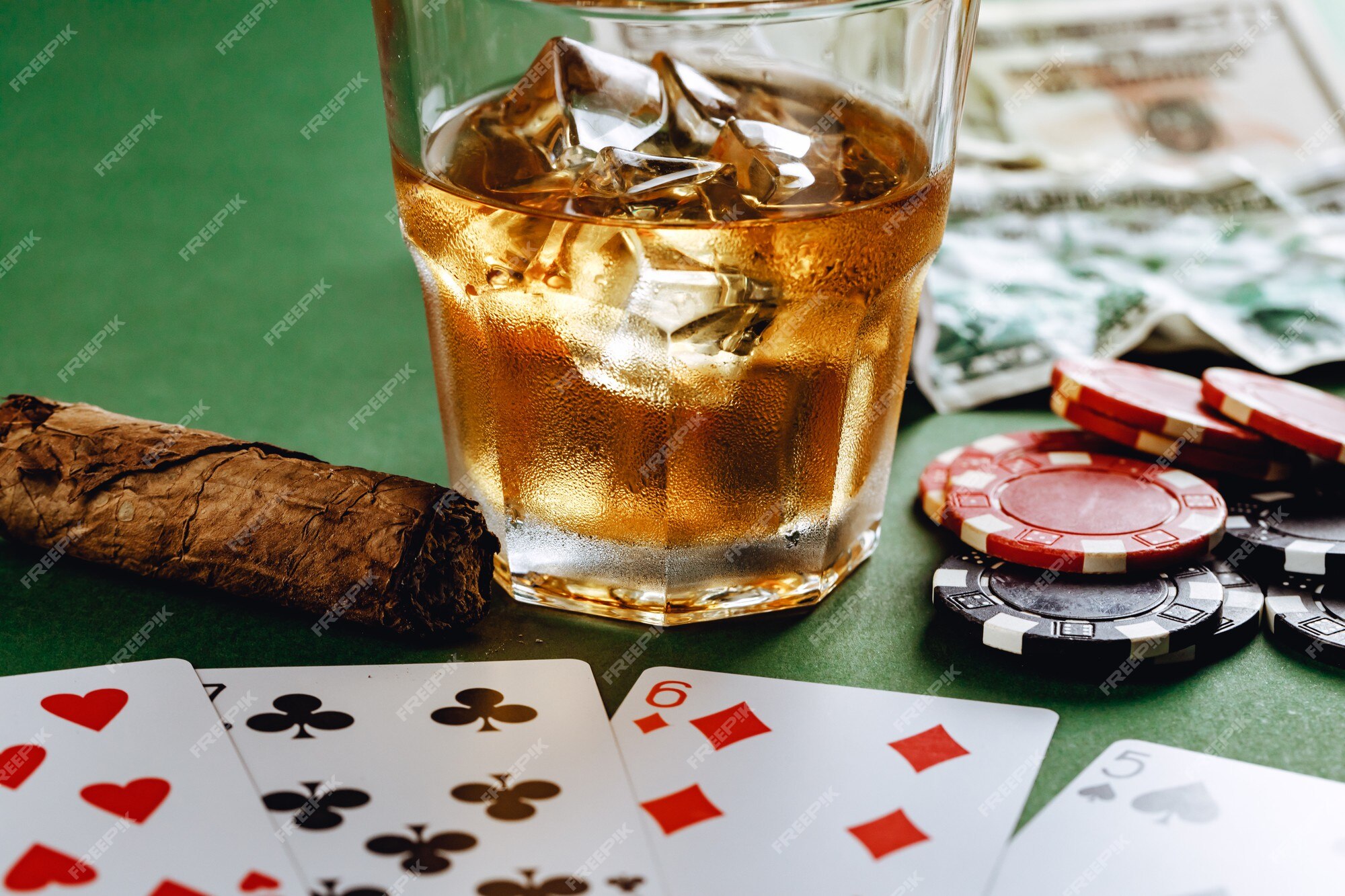 Copo de whisky charuto jogando cartas e fichas no verde