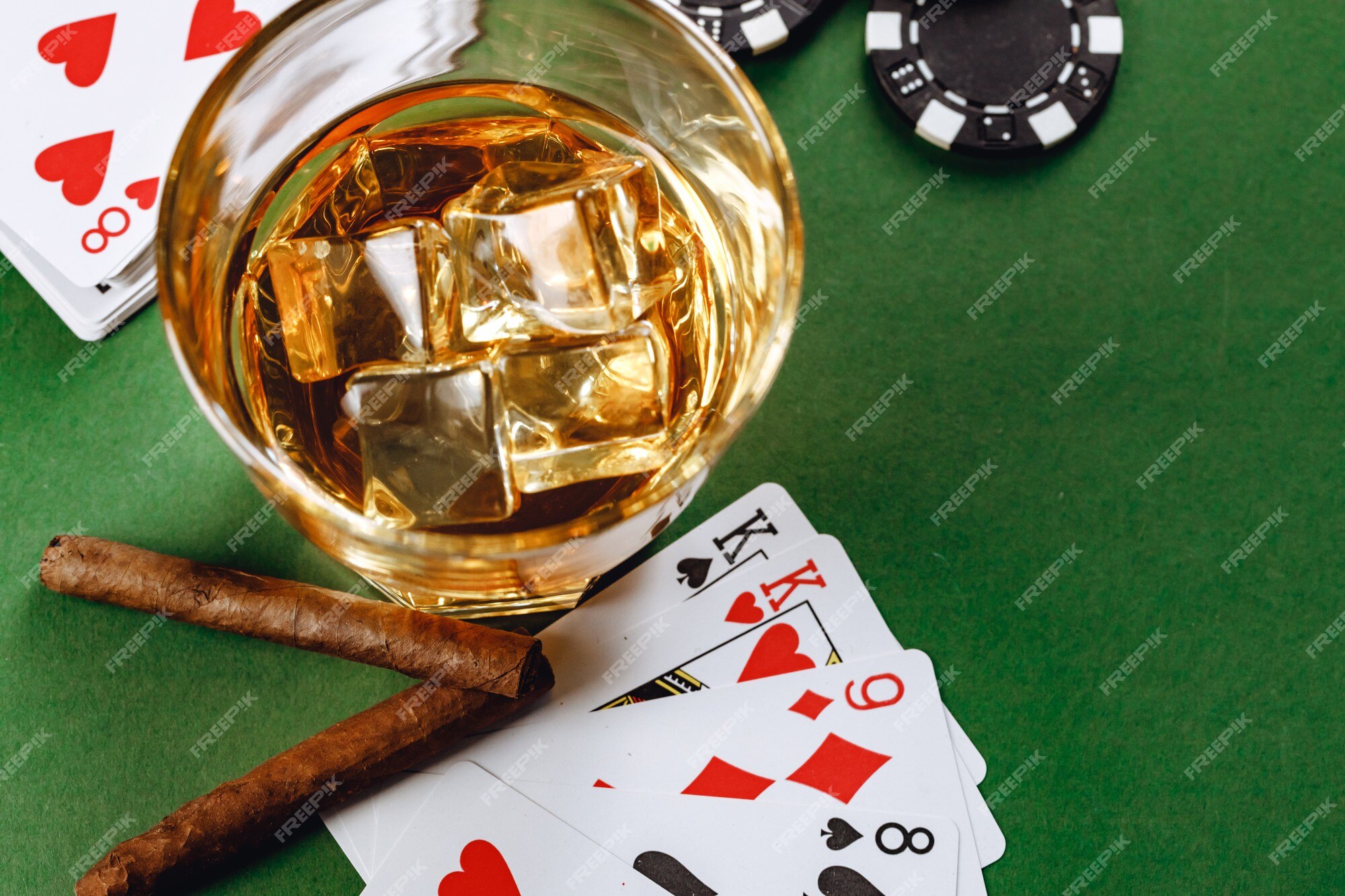 Copo de whisky charuto jogando cartas e fichas no verde