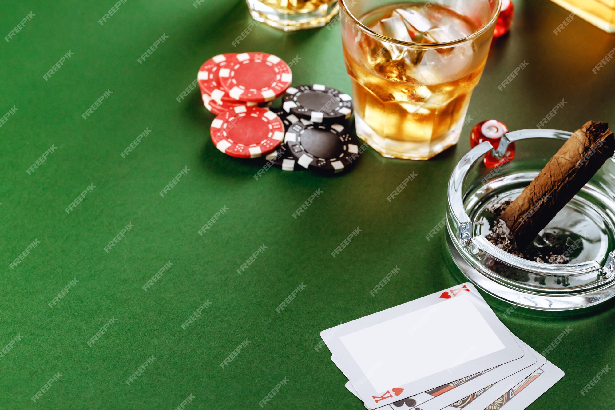 Copo de whisky charuto jogando cartas e fichas na superfície verde