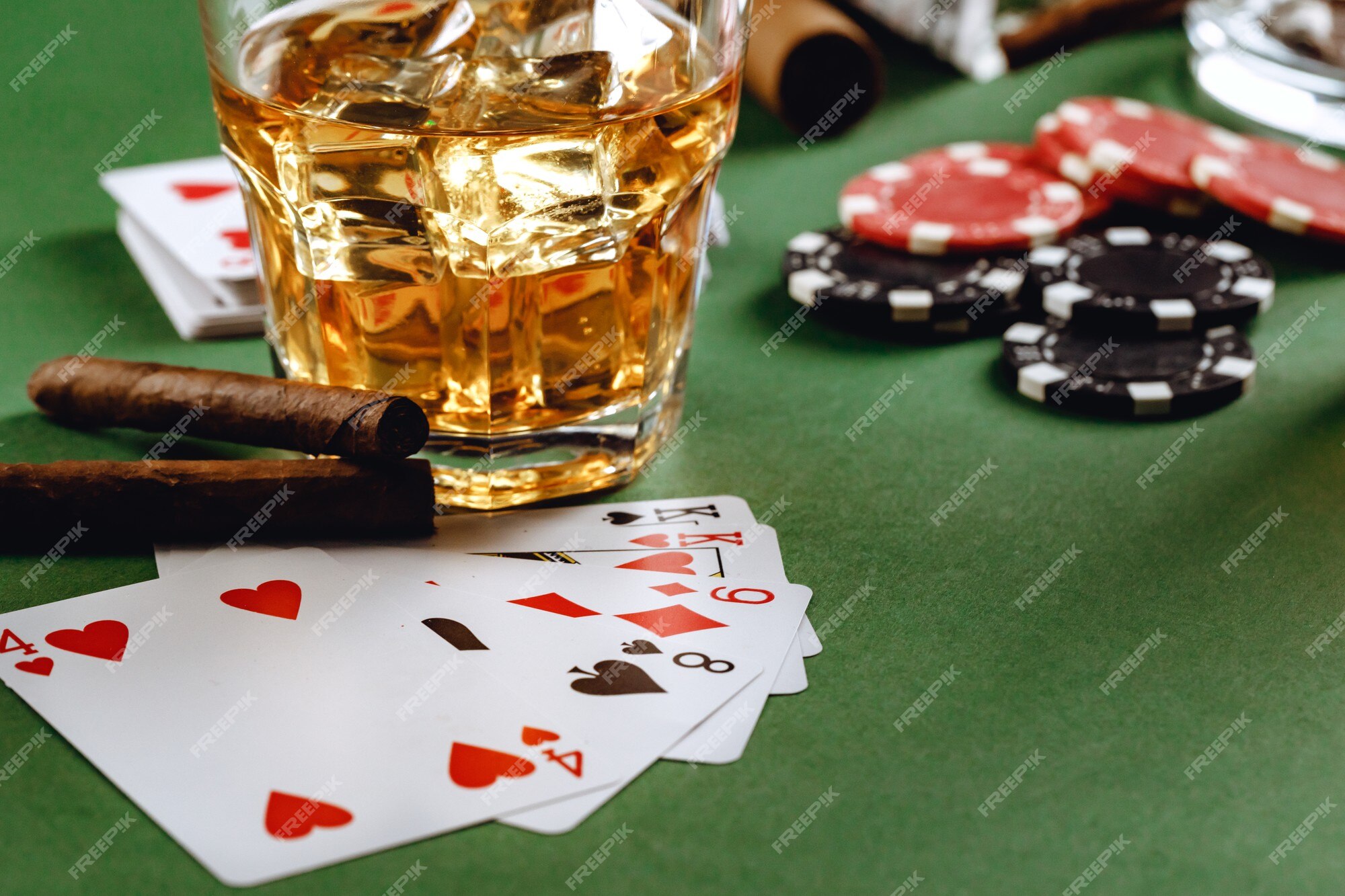 Copo de whisky charuto jogando cartas e fichas no verde