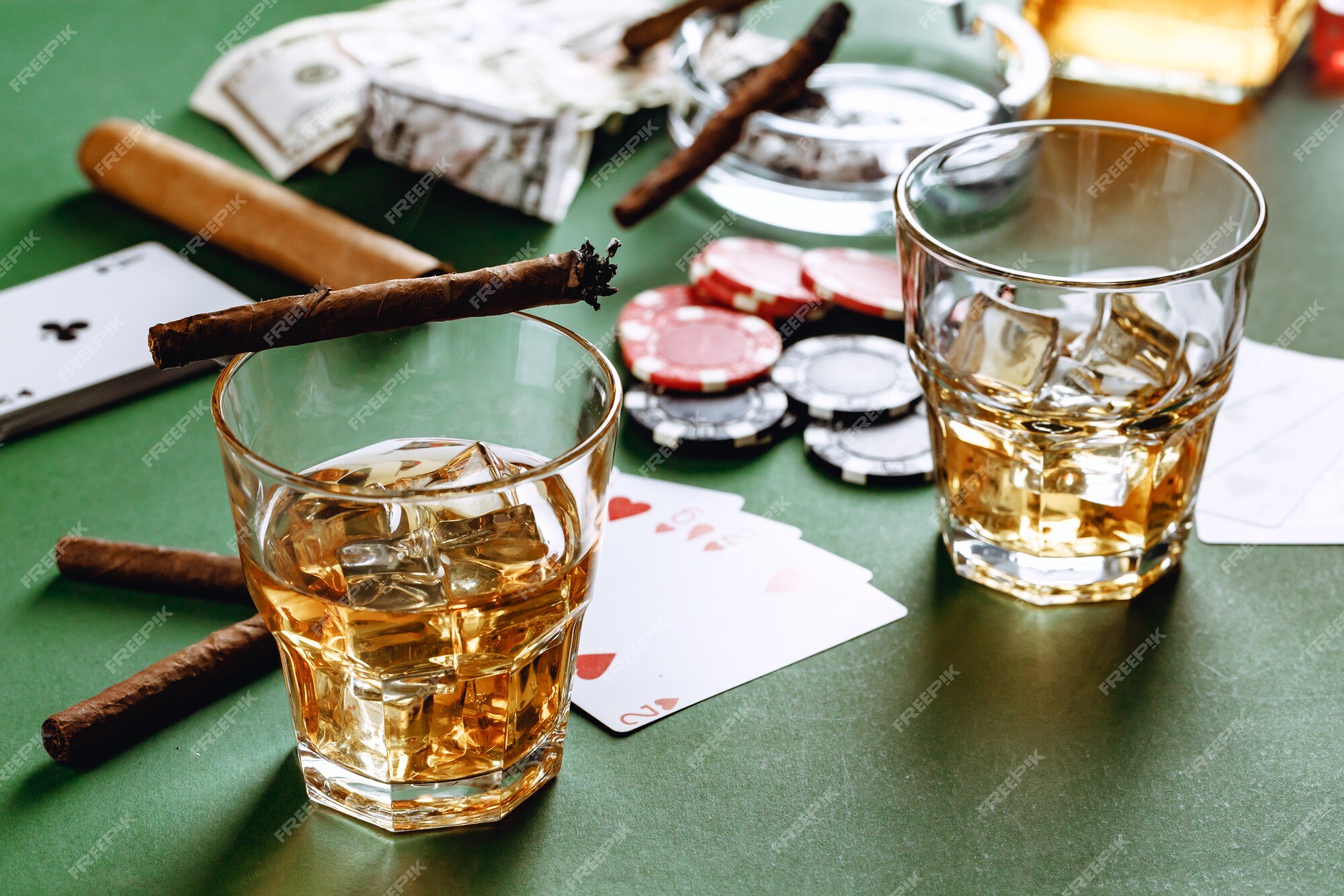 Copo de whisky charuto jogando cartas e fichas no verde