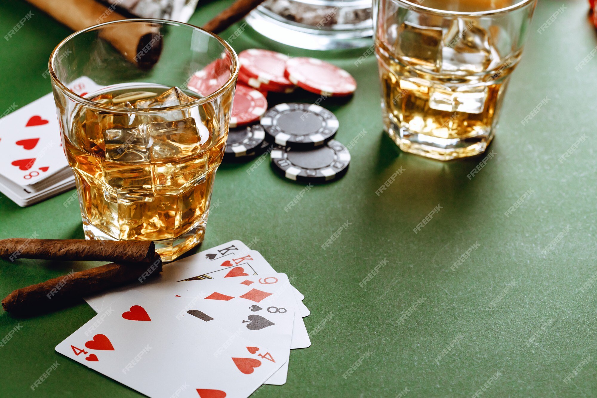 Copo de whisky charuto jogando cartas e fichas no verde