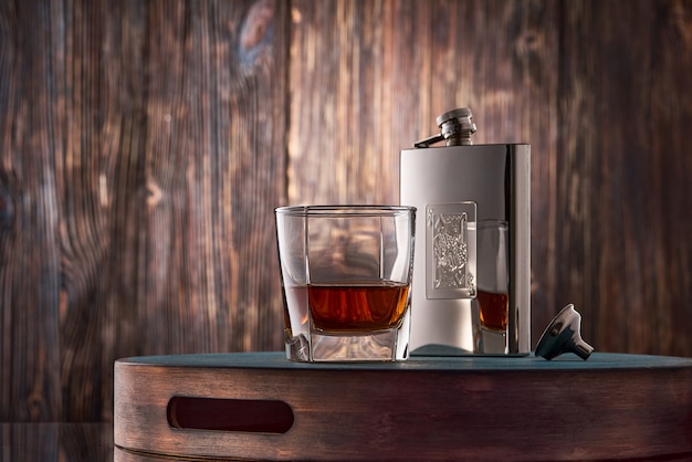 Copo de whisky e um frasco na mesa de madeira