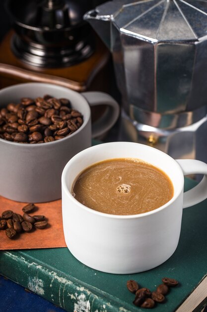 Copo e feijões de café na mesa de cozinha velha.