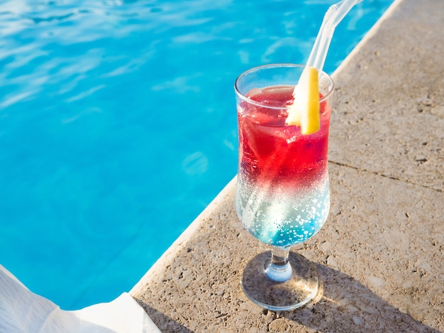 Copo lindo com um coquetel refrescante no fundo da piscina