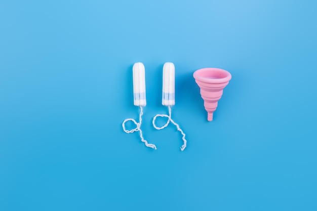 Foto copo menstrual amarelo de silicone copo de escolha ou tampões para mulheres em fundo azul ecologicamente correto