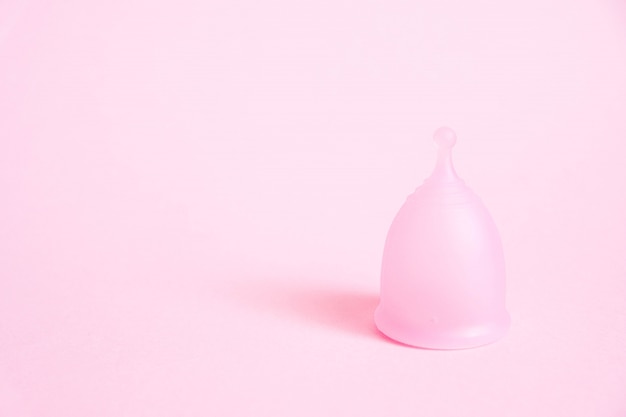 Copo menstrual no fundo rosa. Produto alternativo de higiene feminina durante o período. Conceito de saúde de mulheres.