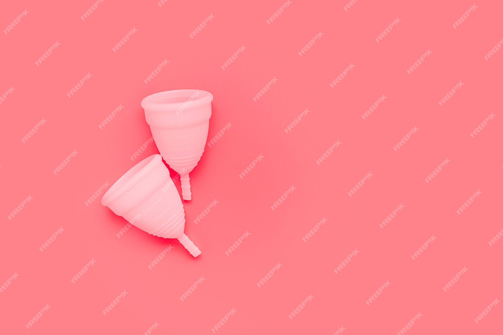 mão de uma mulher segurando o copo menstrual rosa isolado no fundo branco.  mulher moderna alternativa eco ginecológica higiene no período de  menstruação. recipiente para sangue na mão da menina. 5427428 Foto