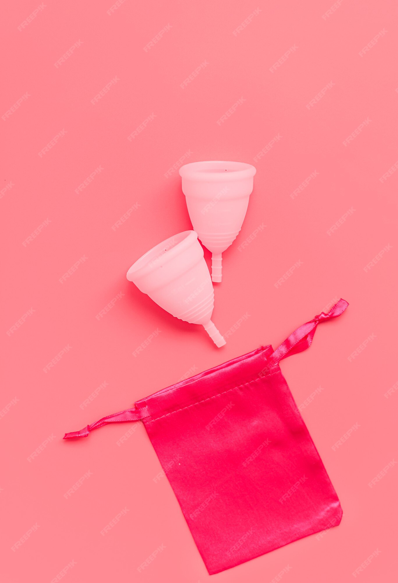 Copo menstrual branco com corações vermelhos simbolizando a menstruação em  rosa