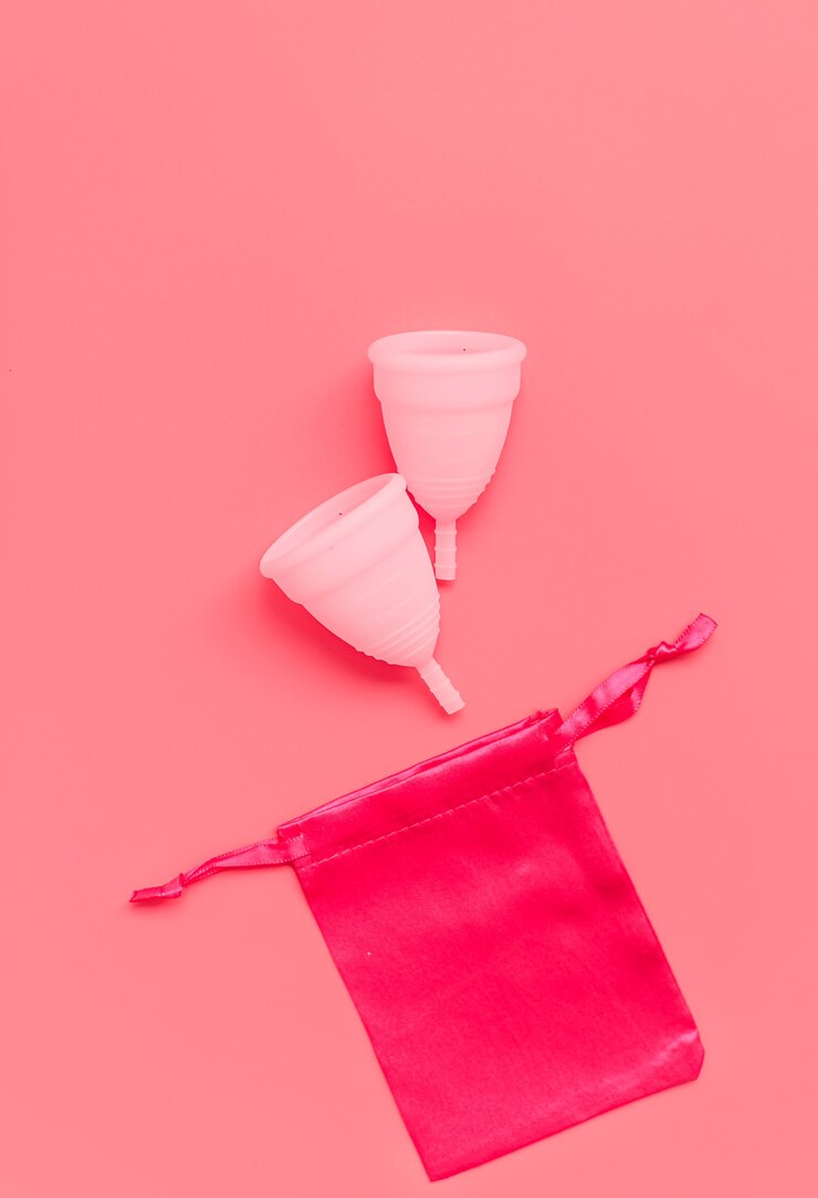 Copo menstrual rosa na cor de fundo produtos femininos de higiene íntima de época vista superior