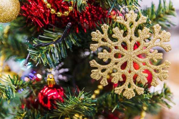 Copo de nieve de oro en ramas verdes del árbol de navidad. Decoraciones de año nuevo