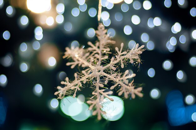 Copo de nieve sobre fondo de luces bokeh adornos navideños atmósfera de año nuevo