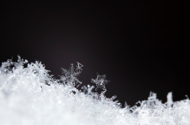 Copo de nieve sobre ventisquero natural cerca de fondo de invierno y Navidad