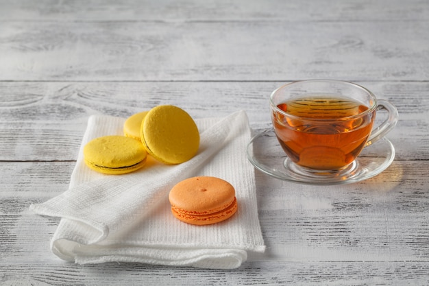 Copo quente de chá em uma mesa de madeira com biscoitos