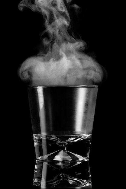 Copo vazio com vapor sobre um fundo preto. simboliza o elemento ar