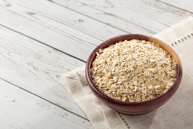 Copos de avena en cuenco de madera