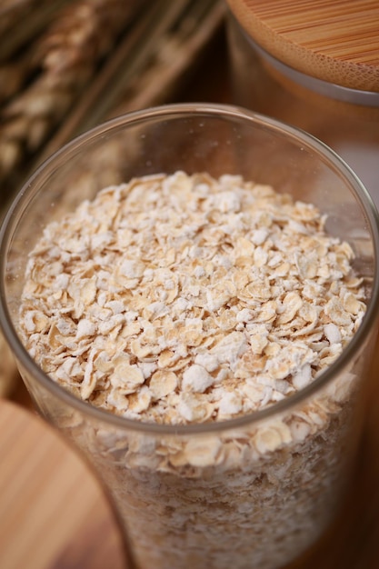 Copos de avena en un frasco con cuchara en la mesa