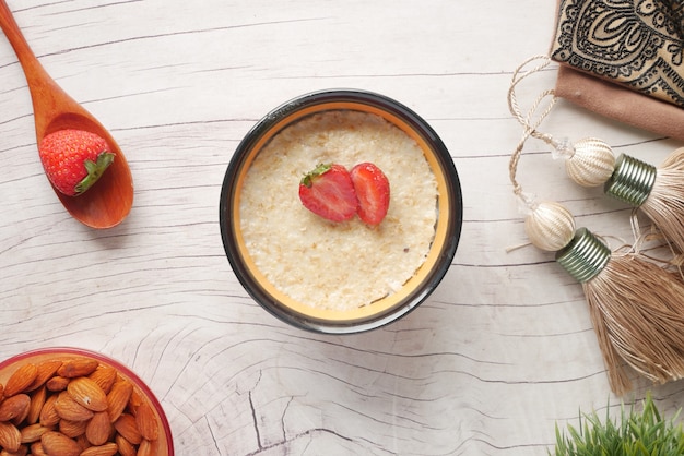 Copos de avena y fresa en mesa de madera