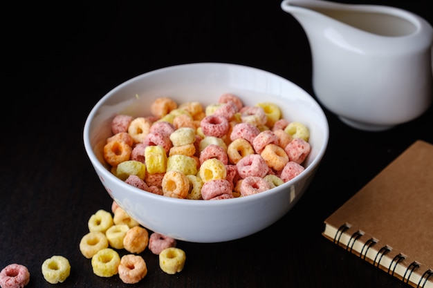 Copos de cereales en un tazón con espacio de copia, concepto de desayuno. Alimentos con delicioso sabor afrutado y colores afrutados. Está hecho con maíz, trigo y cebada.