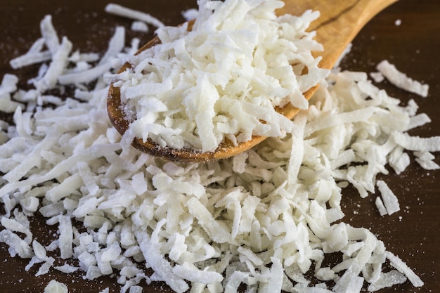 Copos de coco deshidratado sobre un fondo de madera.