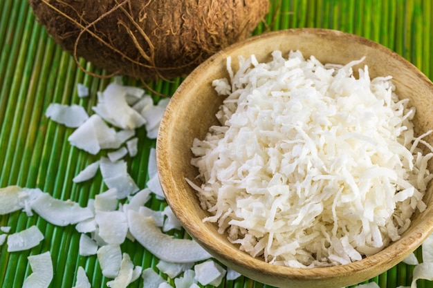 Copos de coco deshidratado en un tazón de madera.