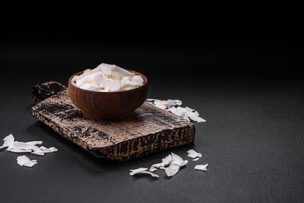 Copos de coco secos blancos en un cuenco de madera preparado para hacer postres