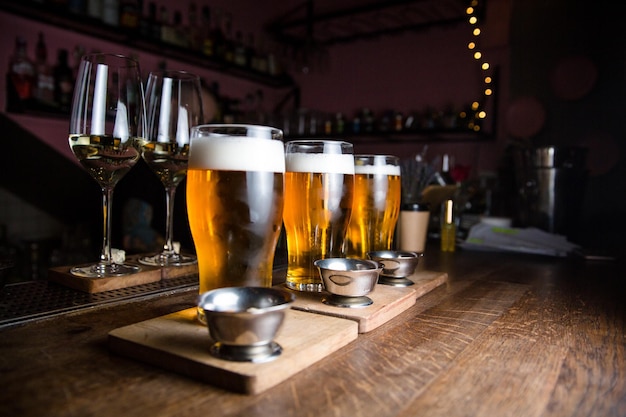 Copos com cerveja em um balcão de bar em um fundo de bar desfocado