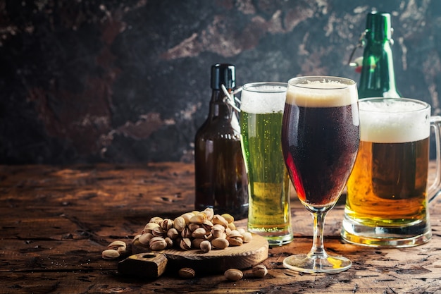 Copos com diferentes tipos de cerveja artesanal na mesa de madeira