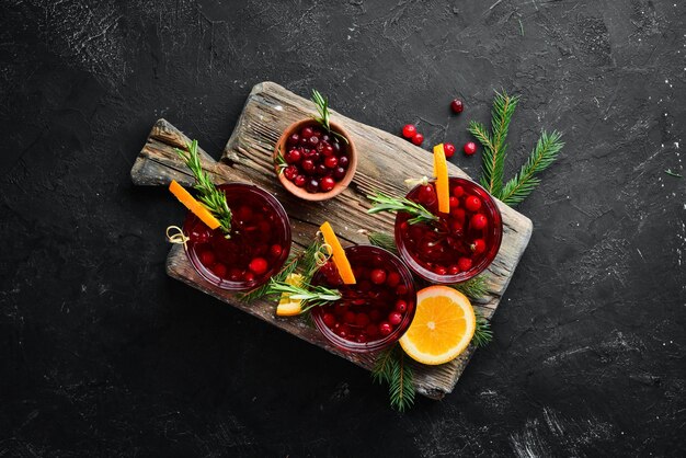 Copos com suco de cranberry Cranberries limões alecrim Em um fundo rústico Vista superior Espaço livre para o seu texto