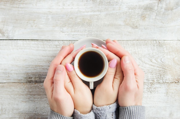 Copos com um café nas mãos de homens e mulheres. foco seletivo. bebida.