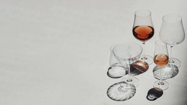 Copos com vinho rosé em um fundo de pedra Estilo plano leigo Tendência de sombras contrastantes
