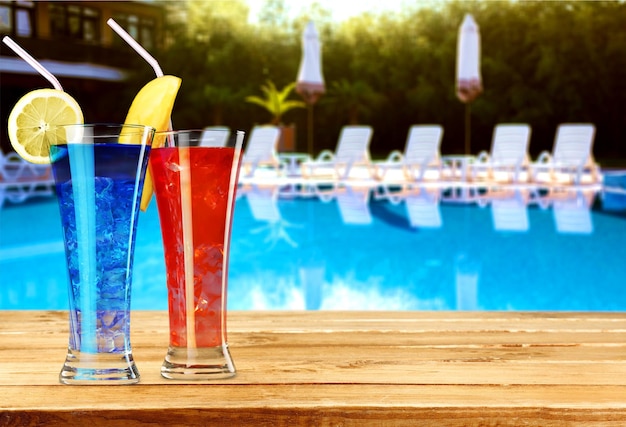 Foto copos de bebidas alcoólicas com gelo e limão no fundo da piscina