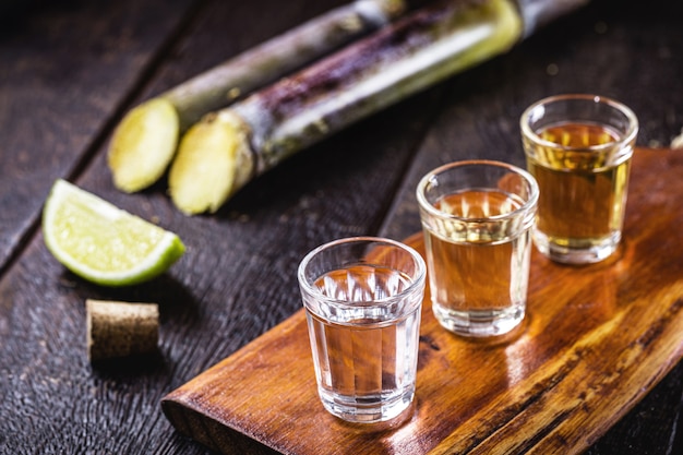 Copos de cachaça, com cana de açúcar ao fundo, bebida brasileira popularmente chamada de 