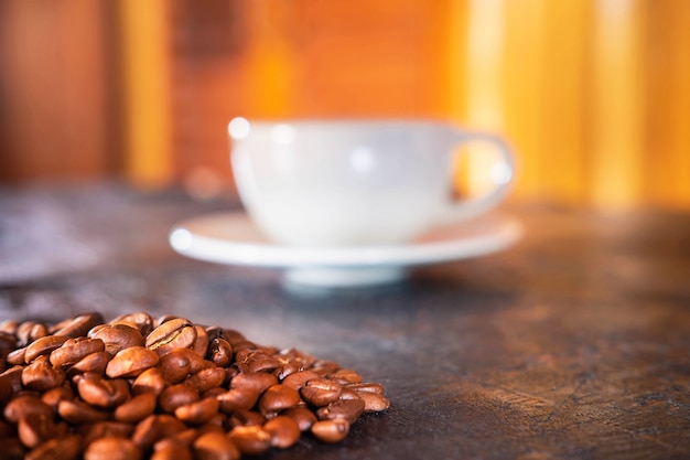 Foto copos de café e grãos de café em uma mesa de madeira