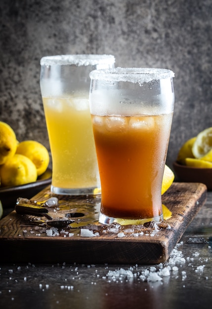 Copos de cerveja com gelo na placa de madeira