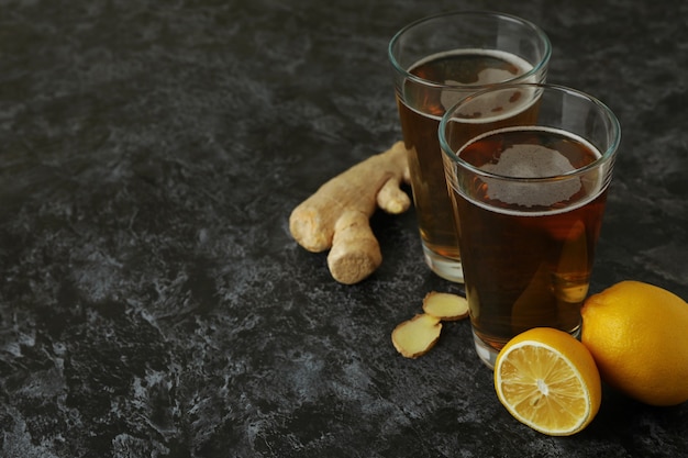 Foto copos de cerveja de gengibre e ingredientes em fundo preto esfumaçado