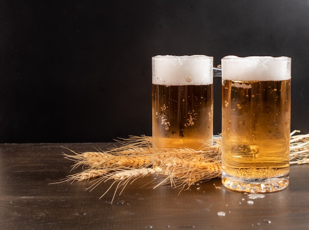Copos de cerveja em mesa de madeira