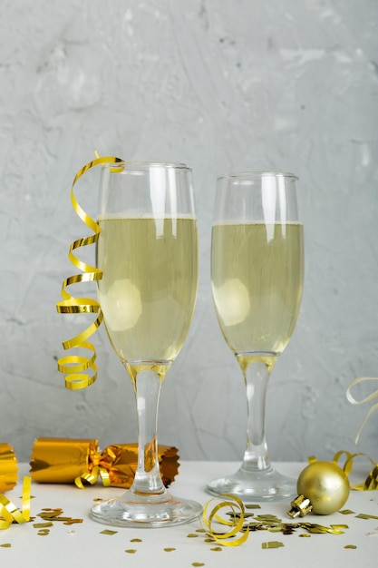 Copos de champanhe e decoração de Natal em fundo de férias coloridas Decorações de Ano Novo planas